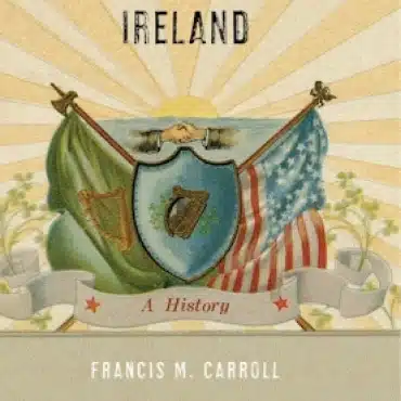 Book cover titled "Ireland: A History" by Francis M. Carroll, featuring crossed Irish and American flags, a harp on a shield, and a sunrise background—highlighting events like Demilitarising Saint Patrick’s Day 1921 beneath the banner reading "A History.