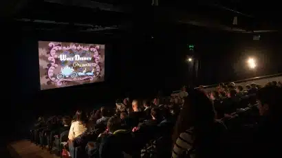 A group of people in a theatre gathered to explore Waterford St Patrick’s Day Festival, sharing laughter and anticipation for the festivities ahead.
